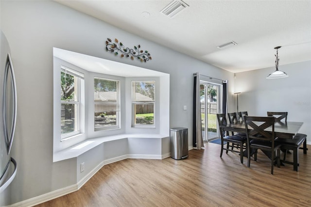 dining room with light wood-style flooring, baseboards, and visible vents