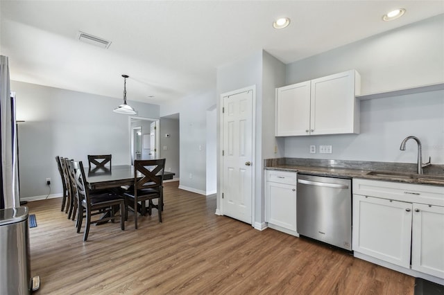kitchen featuring stainless steel dishwasher, light wood-style floors, white cabinets, and a sink