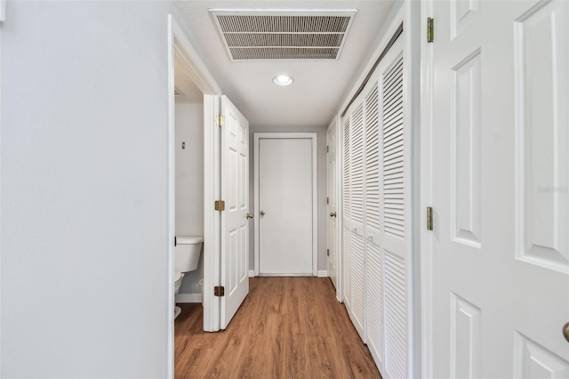 hall with light wood-style floors and visible vents