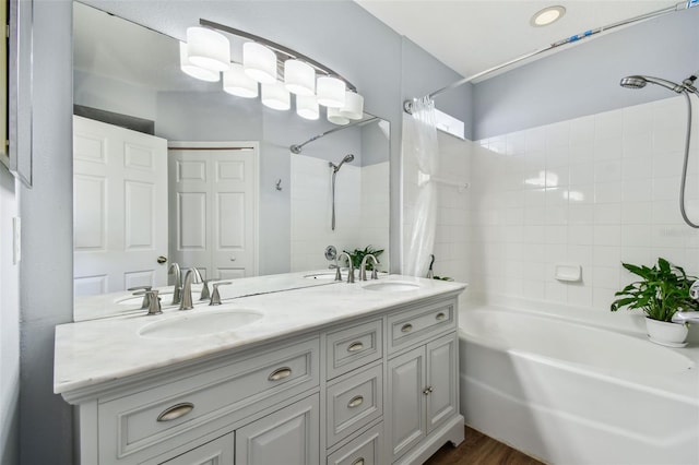 bathroom featuring shower / bath combo, wood finished floors, double vanity, and a sink
