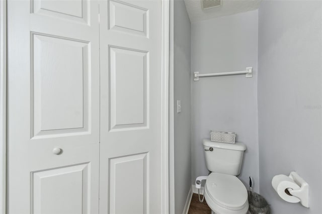 bathroom with visible vents, toilet, and baseboards