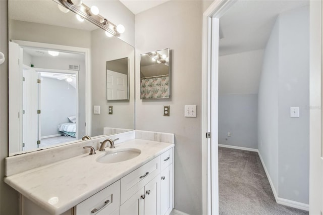 bathroom featuring visible vents, baseboards, a ceiling fan, vanity, and vaulted ceiling