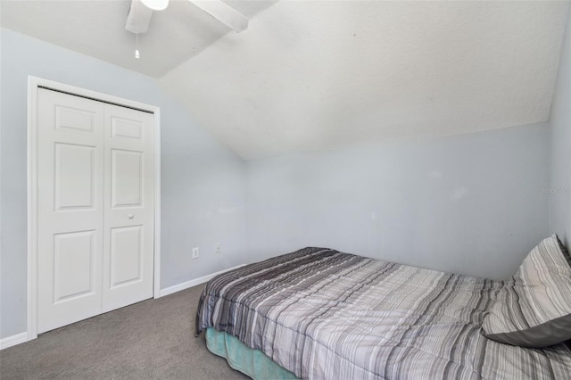 carpeted bedroom featuring a closet, baseboards, a ceiling fan, and vaulted ceiling