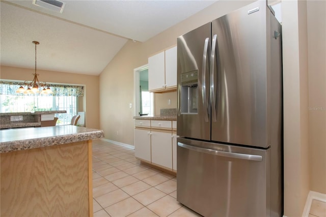 kitchen featuring light tile patterned floors, white cabinetry, visible vents, stainless steel fridge, and lofted ceiling