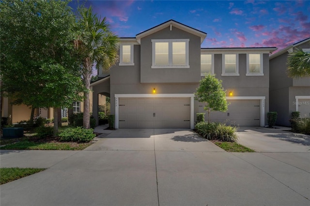 view of front of property featuring a garage, driveway, and stucco siding
