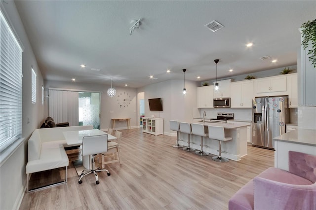 living room with light wood-style flooring, baseboards, visible vents, and recessed lighting