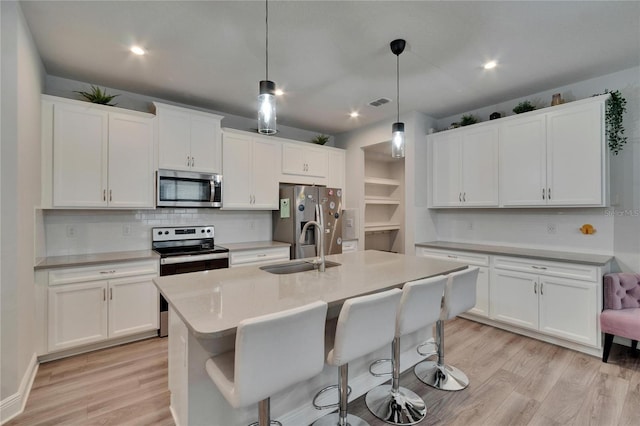 kitchen featuring light wood-style floors, light countertops, a sink, and appliances with stainless steel finishes