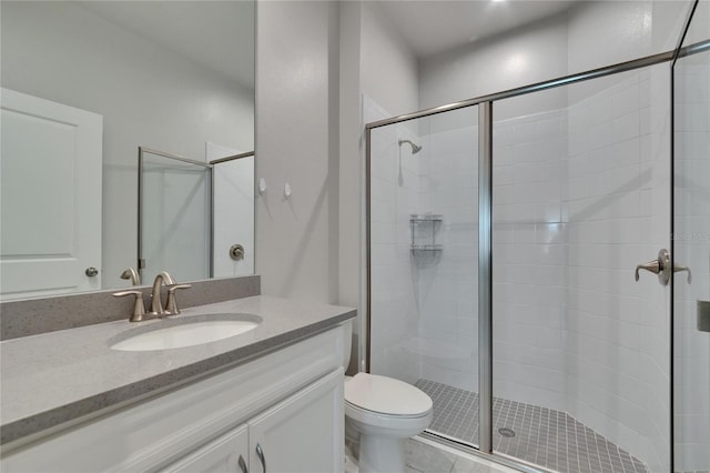 bathroom featuring toilet, a stall shower, vanity, and tile patterned flooring