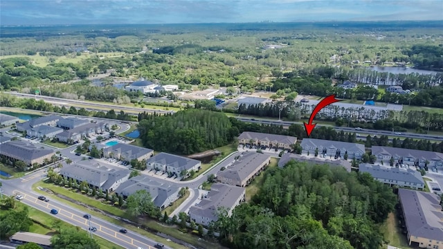drone / aerial view featuring a wooded view and a water view