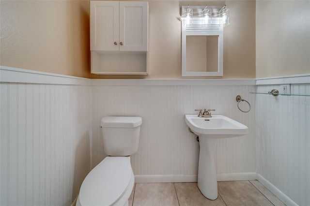 11386 Churchhill Trl, Seminole, FL 33772 - bathroom with toilet, tile patterned floors, and a wainscoted wall