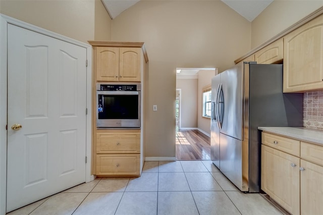 11386 Churchhill Trl, Seminole, FL 33772 - kitchen with light countertops, backsplash, light tile patterned flooring, stainless steel appliances, and light brown cabinetry