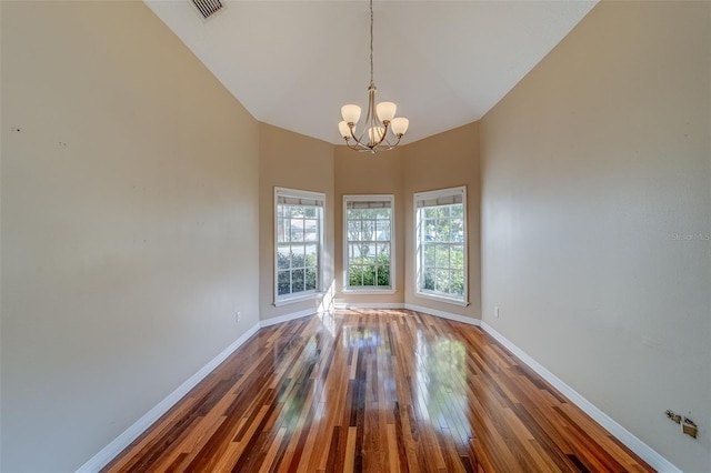 11386 Churchhill Trl, Seminole, FL 33772 - unfurnished room with a notable chandelier, baseboards, hardwood / wood-style floors, and lofted ceiling