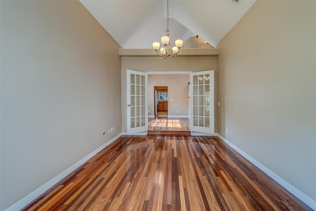 11386 Churchhill Trl, Seminole, FL 33772 - empty room with baseboards, a chandelier, wood finished floors, french doors, and high vaulted ceiling
