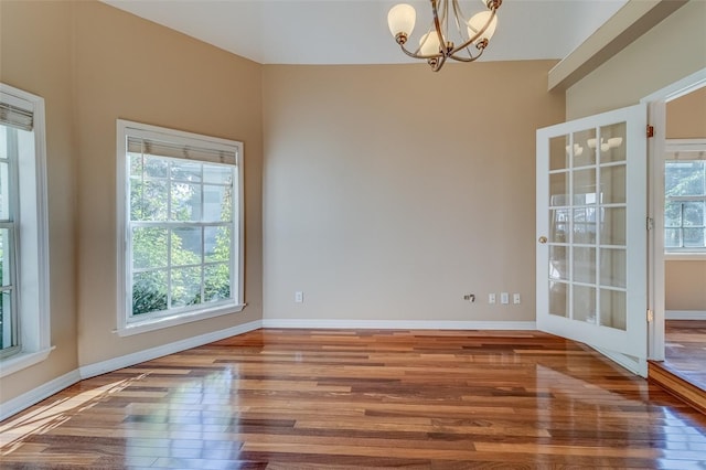 11386 Churchhill Trl, Seminole, FL 33772 - spare room featuring baseboards, a chandelier, and wood finished floors