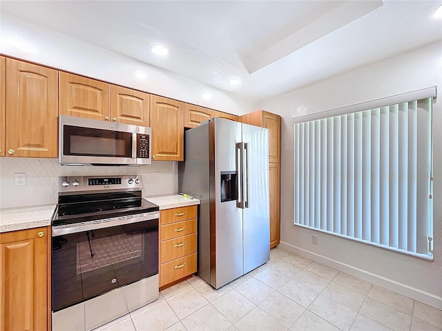kitchen featuring light tile patterned floors, recessed lighting, appliances with stainless steel finishes, light countertops, and baseboards