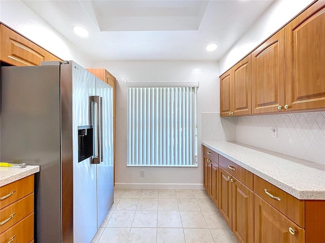 kitchen featuring stainless steel fridge with ice dispenser, backsplash, recessed lighting, and brown cabinets