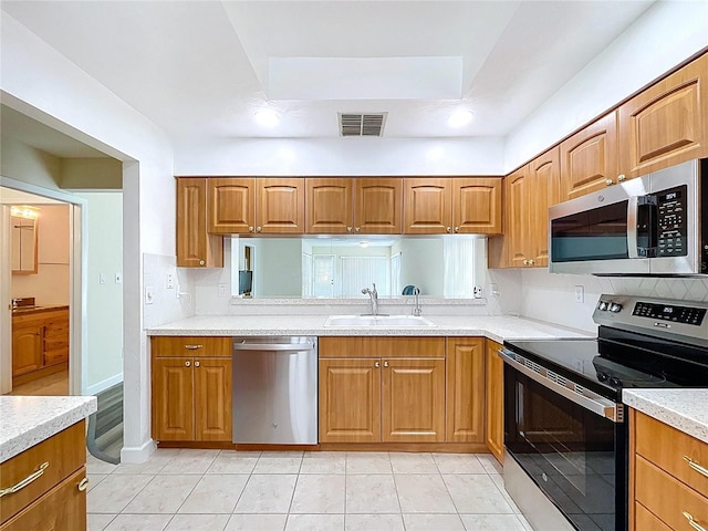 kitchen featuring light countertops, appliances with stainless steel finishes, a sink, and visible vents