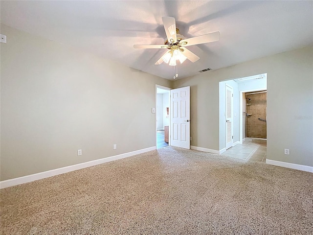 empty room with visible vents, baseboards, a ceiling fan, and light carpet