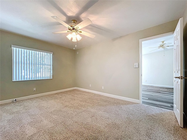 spare room with carpet, baseboards, and ceiling fan