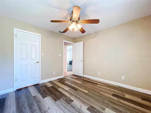 spare room with ceiling fan, dark wood-style flooring, baseboards, and visible vents