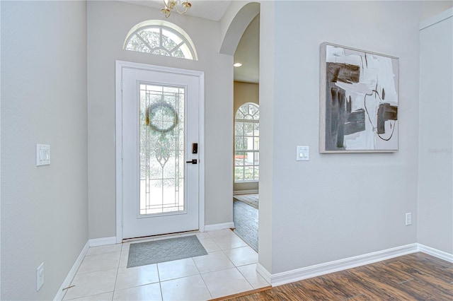 16501 Sandhill Crane Dr, Spring Hill, FL 34610 - foyer entrance with arched walkways, baseboards, and light tile patterned floors