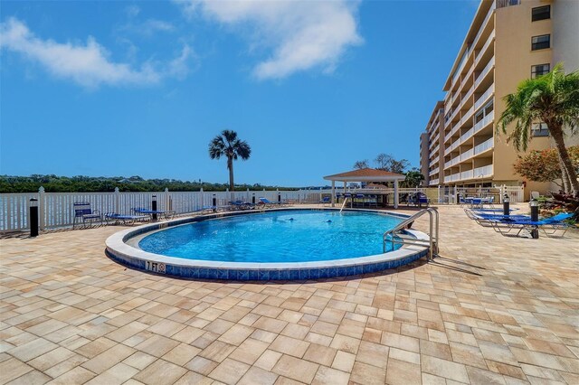 community pool featuring fence, a gazebo, and a patio area