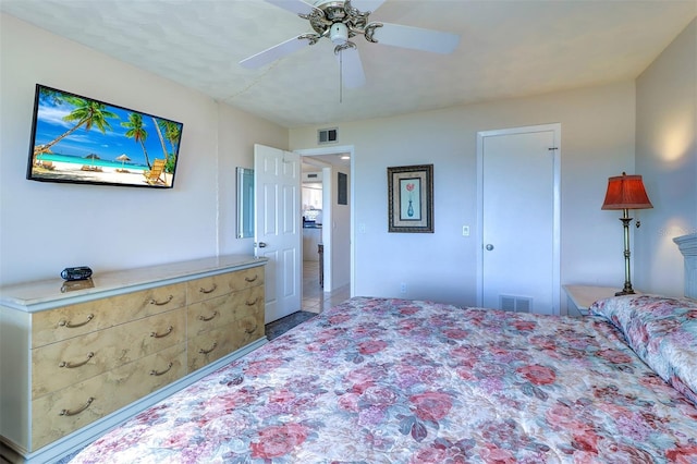 bedroom featuring tile patterned flooring, visible vents, and ceiling fan