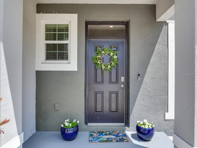 property entrance with stucco siding