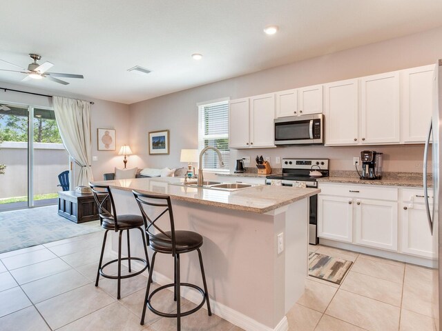 kitchen featuring a kitchen bar, plenty of natural light, stainless steel appliances, and a sink
