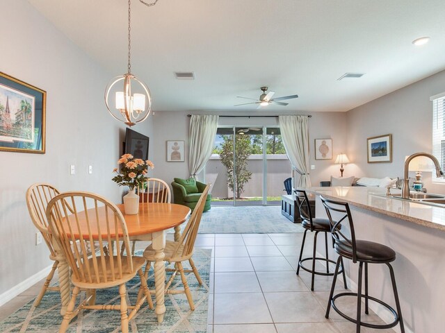 dining area featuring a wealth of natural light, ceiling fan with notable chandelier, visible vents, and light tile patterned floors