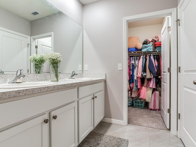 full bathroom with double vanity, visible vents, tile patterned flooring, and a sink