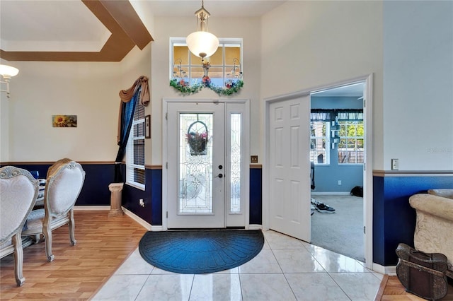 tiled entrance foyer with baseboards and a high ceiling