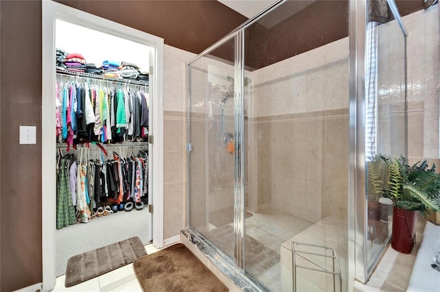 full bathroom with a stall shower and a walk in closet