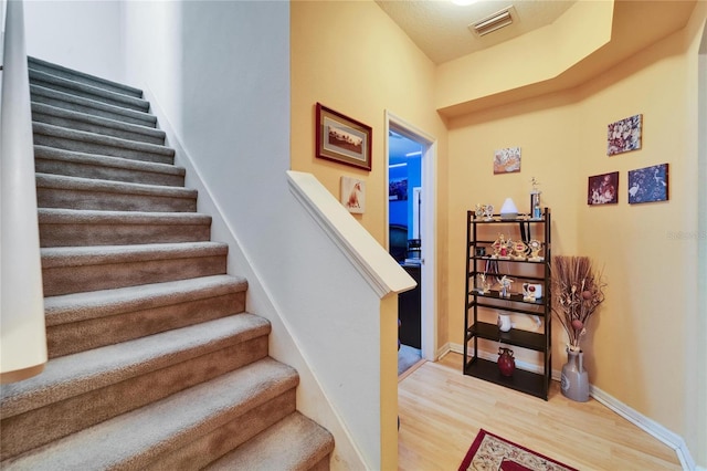 staircase with wood finished floors and baseboards