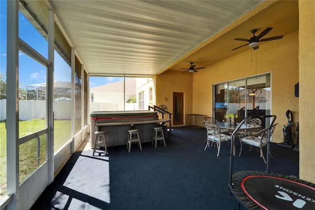 sunroom / solarium with plenty of natural light, ceiling fan, and a hot tub