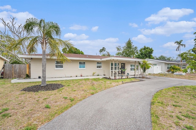 831 72nd Ave N, Saint Petersburg, FL 33702 - ranch-style house with a front lawn, fence, and aphalt driveway