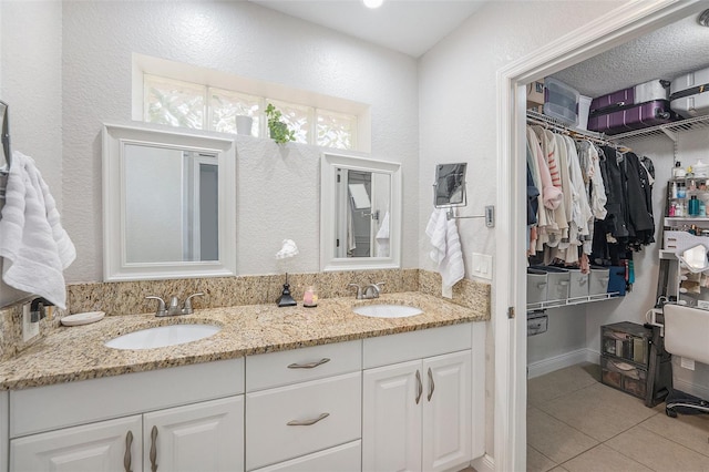 831 72nd Ave N, Saint Petersburg, FL 33702 - bathroom featuring tile patterned floors, double vanity, a sink, and a spacious closet