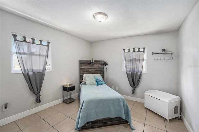 831 72nd Ave N, Saint Petersburg, FL 33702 - bedroom featuring a textured ceiling, light tile patterned floors, and baseboards