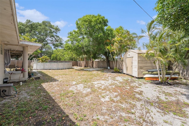 831 72nd Ave N, Saint Petersburg, FL 33702 - view of yard with a pool, a fenced backyard, an outdoor structure, and a storage unit
