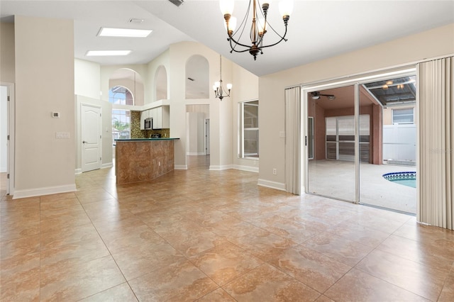 18005 Palm Breeze Dr, Tampa, FL 33647 - unfurnished dining area with high vaulted ceiling, an inviting chandelier, baseboards, and visible vents