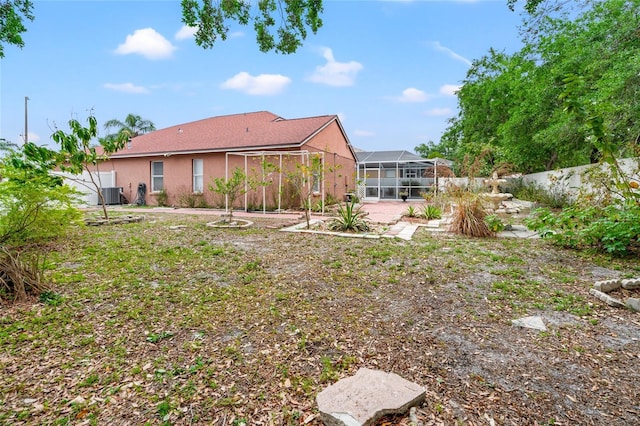 18005 Palm Breeze Dr, Tampa, FL 33647 - view of yard featuring a patio, central AC unit, a fenced backyard, and a lanai