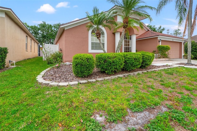 18005 Palm Breeze Dr, Tampa, FL 33647 - view of front facade featuring a front yard, an attached garage, driveway, and stucco siding