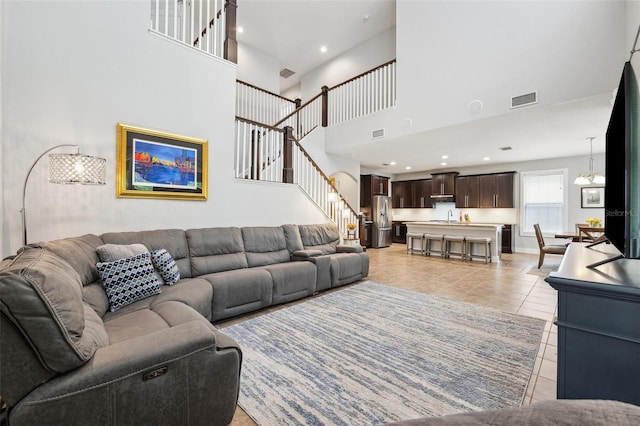 living room featuring light tile patterned floors, recessed lighting, visible vents, and stairway