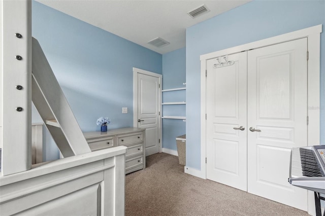 interior space with light carpet, visible vents, a closet, and baseboards