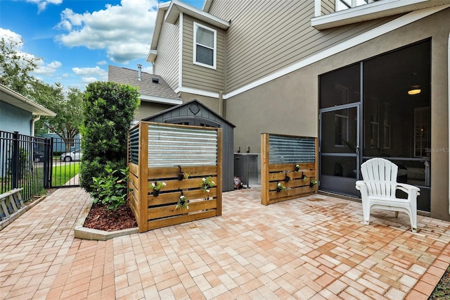 view of patio / terrace featuring fence and a sunroom