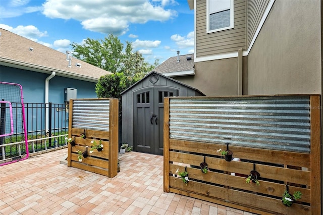 exterior space with a storage shed, fence, a patio, and an outbuilding