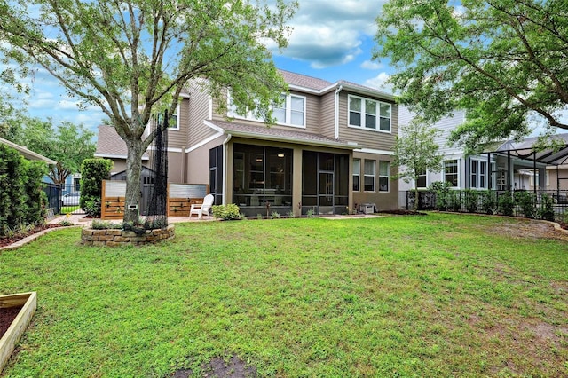 rear view of house featuring a yard, a fenced backyard, and a sunroom