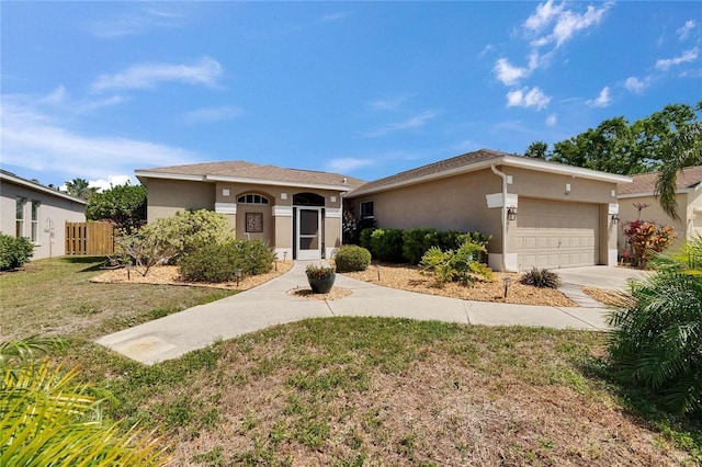 ranch-style home with fence, an attached garage, stucco siding, concrete driveway, and a front lawn