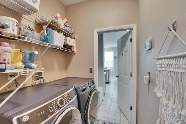 laundry area featuring washer and dryer, laundry area, and light tile patterned flooring