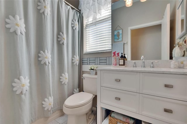 bathroom featuring toilet, vanity, and curtained shower